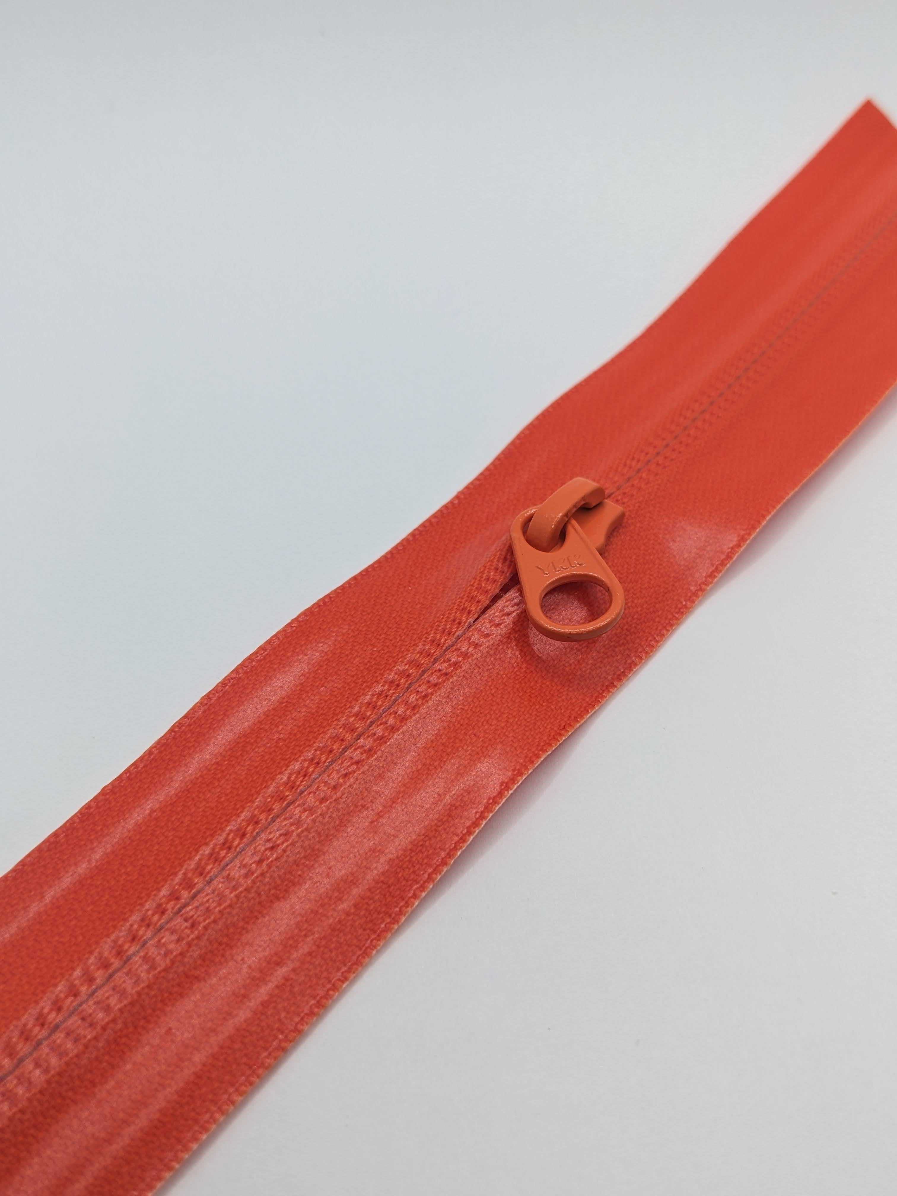 YKK's AquaGuard® NATULON® series is an eco-friendly water-repellent zipper option created by laminating polyurethane (PU) on the non-coil, reverse side of a zipper. The NATULON style is the new sustainable standard for all YKK Aquaguard products.   YKK's AquaGuard® NATULON® updates include:  Recycled polyester tape (which helps reduce CHG emissions) PFC free water repellant finish 20-40% smoother in operation force New smoother appearance