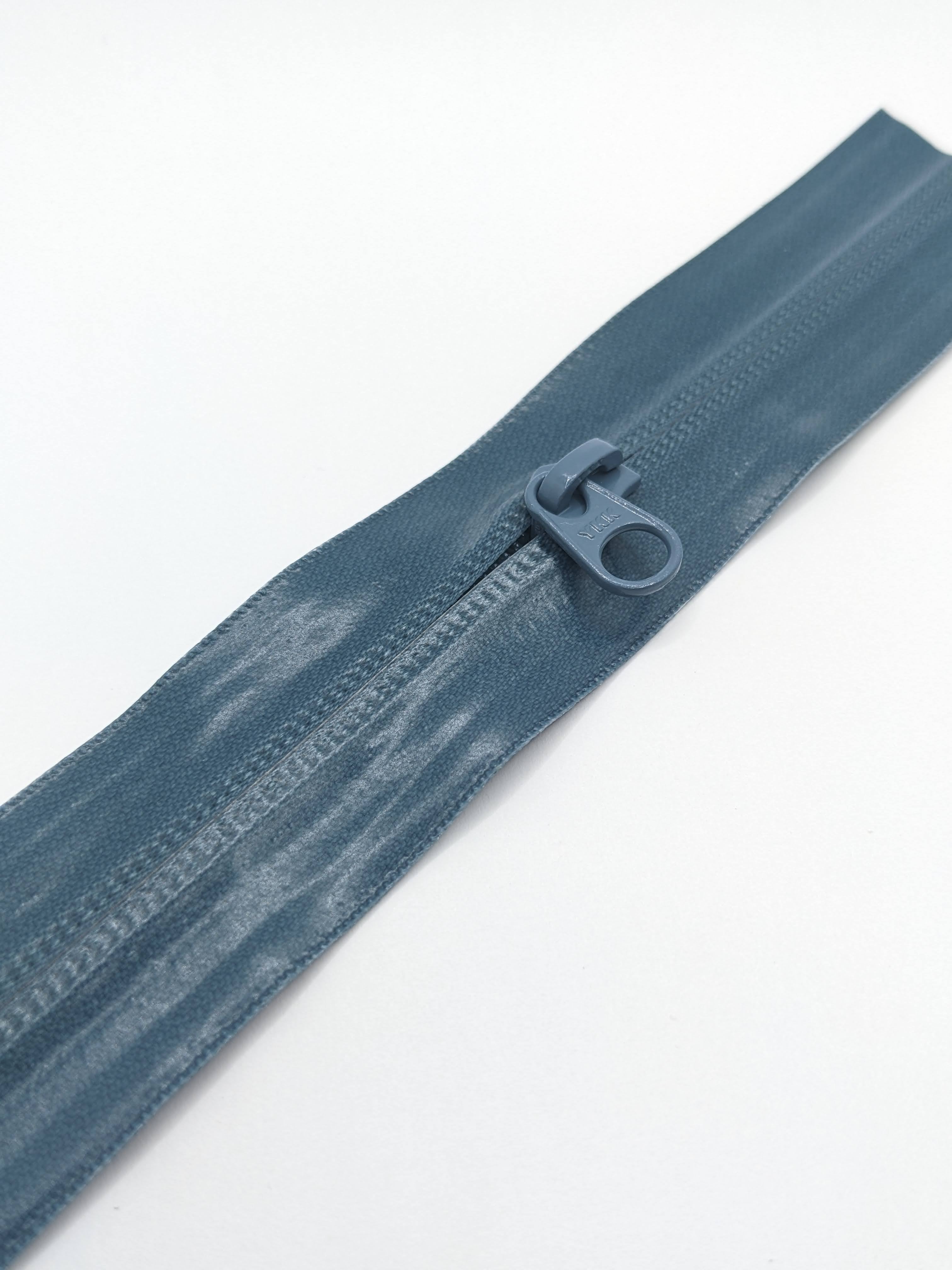 YKK's AquaGuard® NATULON® series is an eco-friendly water-repellent zipper option created by laminating polyurethane (PU) on the non-coil, reverse side of a zipper. The NATULON style is the new sustainable standard for all YKK Aquaguard products.   YKK's AquaGuard® NATULON® updates include:  Recycled polyester tape (which helps reduce CHG emissions) PFC free water repellant finish 20-40% smoother in operation force New smoother appearance