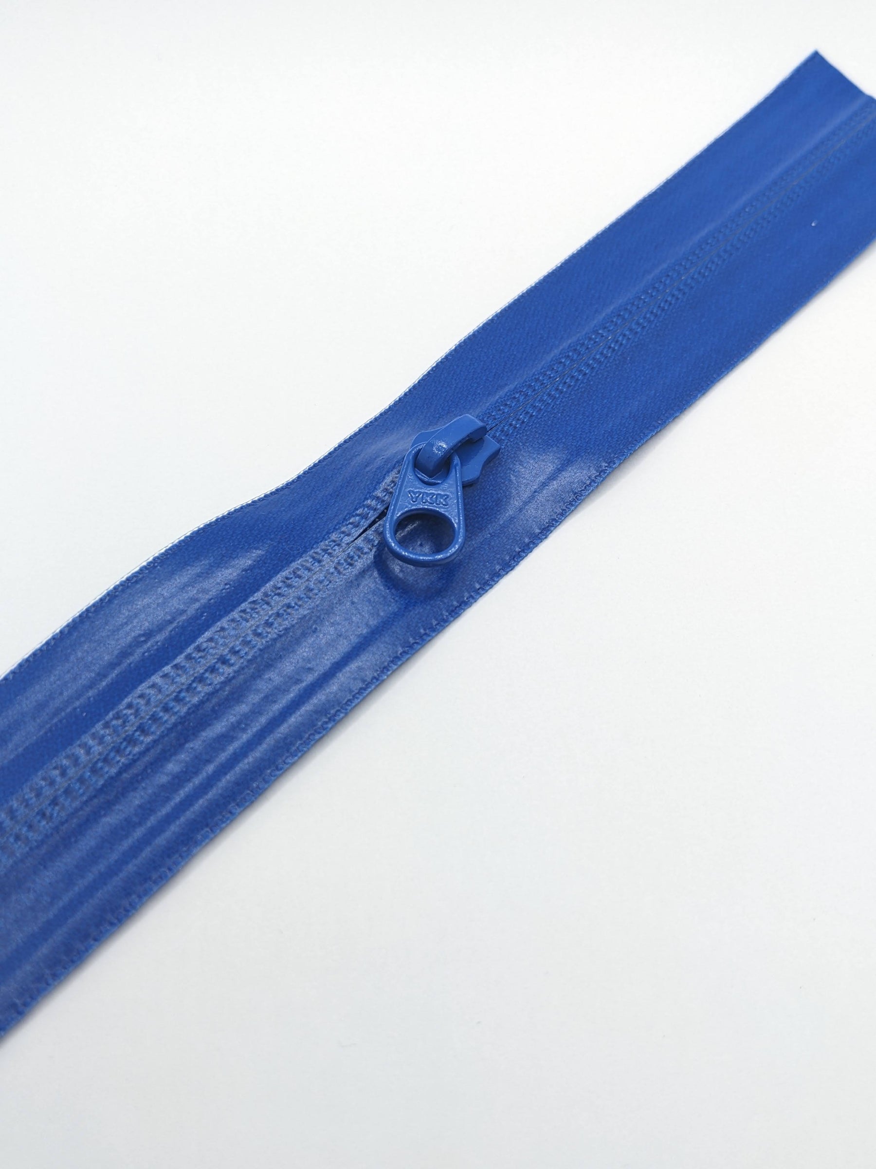 YKK's AquaGuard® NATULON® series is an eco-friendly water-repellent zipper option created by laminating polyurethane (PU) on the non-coil, reverse side of a zipper. The NATULON style is the new sustainable standard for all YKK Aquaguard products.   YKK's AquaGuard® NATULON® updates include:  Recycled polyester tape (which helps reduce CHG emissions) PFC free water repellant finish 20-40% smoother in operation force New smoother appearance